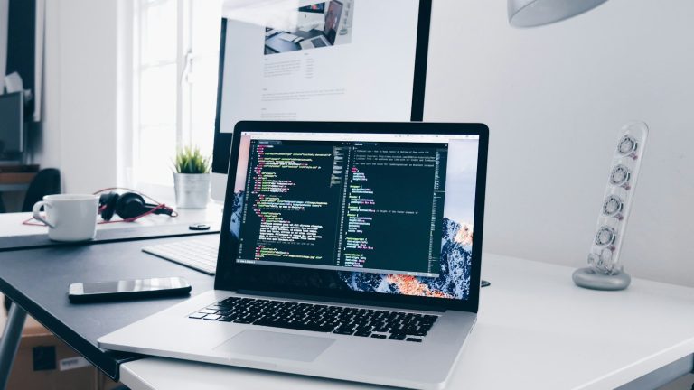 Laptop on a desk showing website code, illustrating Elementor changes not showing because of cache